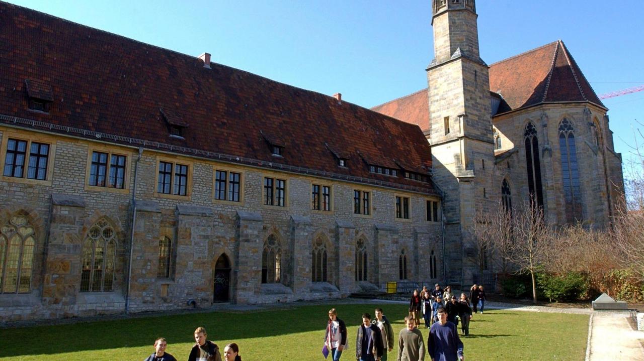Eine Jugendgruppe läuft an der Predigerkirche mit dem Predigerkloster in Erfurt vorbei. Eine Jugendgruppe läuft an der Predigerkirche mit dem Predigerkloster in Erfurt vorbei.