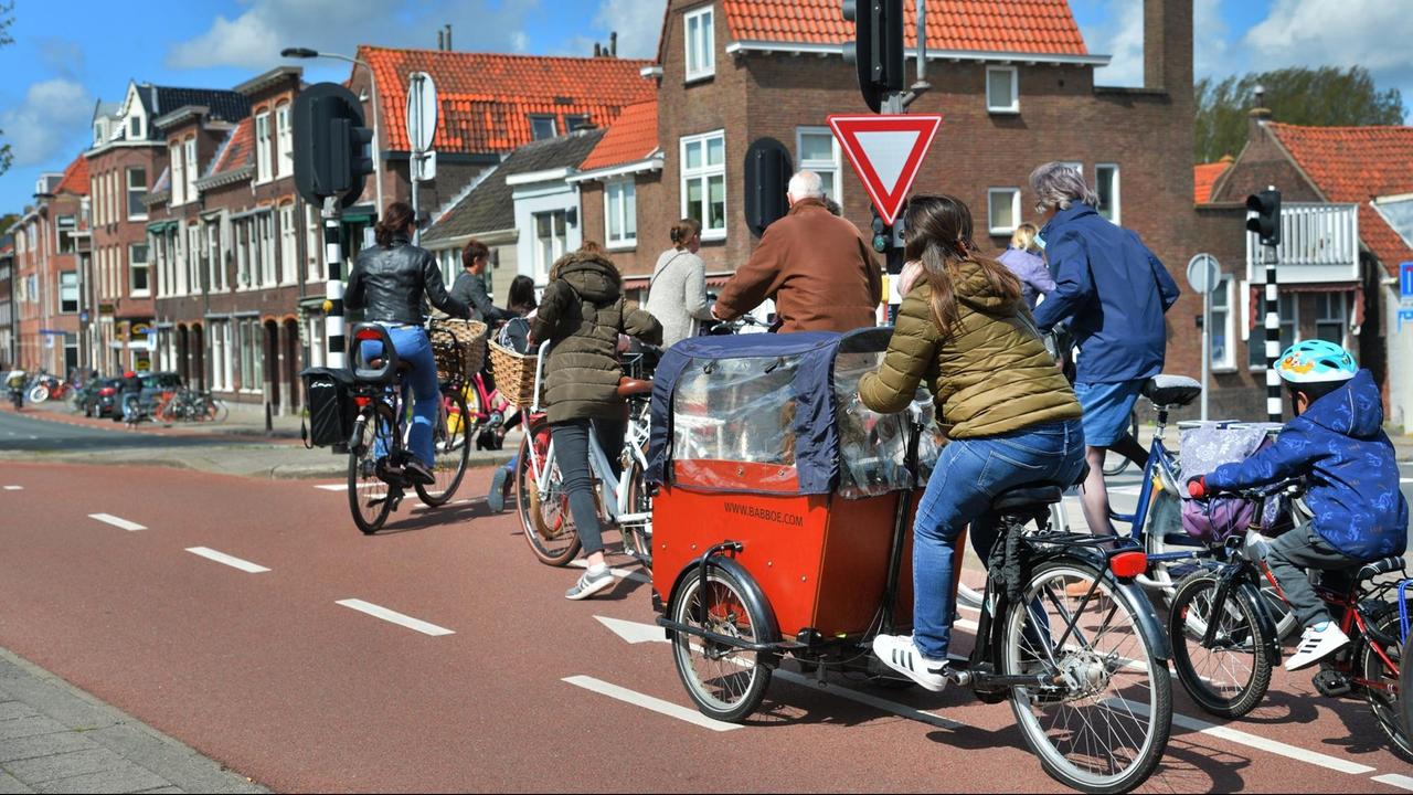 Eine Straßenszene aus dem niederländischen Delft mit vielen Radfahrern. Eine Straßenszene aus dem niederländischen Delft mit vielen Radfahrern.