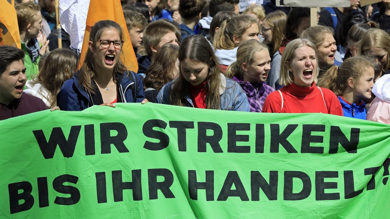 Demonstrierende junge Menschen stehen in Hannover hinter einem Transparent mit der Aufschrift: "Wir streiken bis ihr handelt". Demonstrierende junge Menschen stehen in Hannover hinter einem Transparent mit der Aufschrift: "Wir streiken bis ihr handelt".