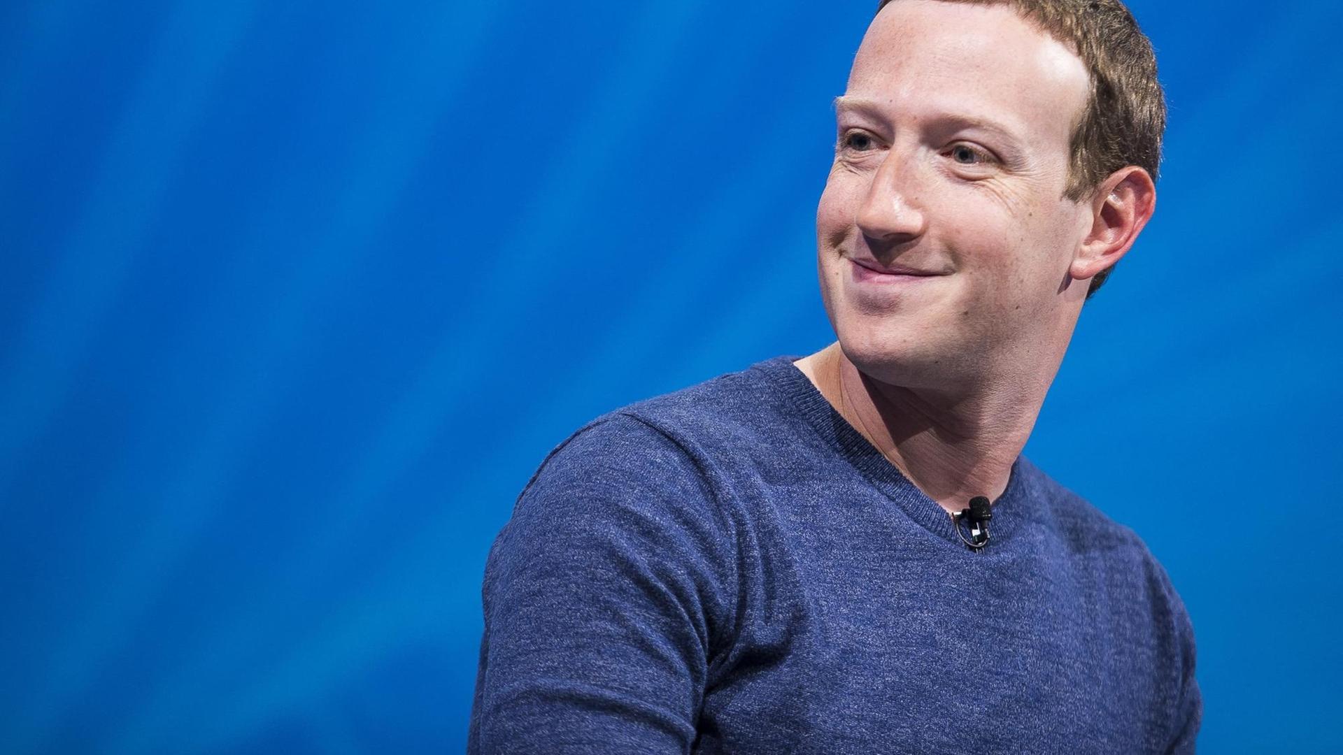 Mark Zuckerberg grinsend auf einer Bühne. Mark Zuckerberg grinsend auf einer Bühne.