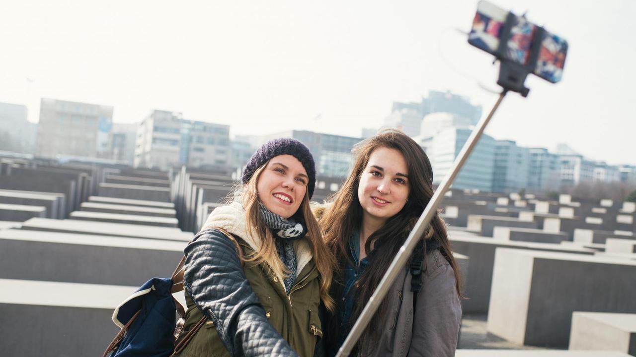 Italienische Touristinnen machen am Holocaust-Denkmal in Berlin ein Selbstporträt mit einem "Selfie-Stick".