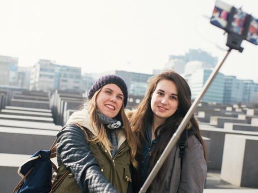 Italienische Touristinnen machen am Holocaust-Denkmal in Berlin ein Selbstporträt mit einem "Selfie-Stick".