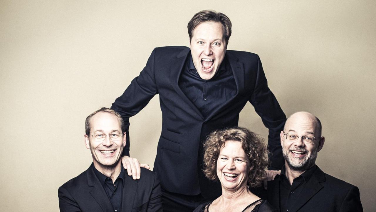 Das vierköpfige Mandelring Quartett lacht ungehemmt in Konzertkleidung in die Kamera.