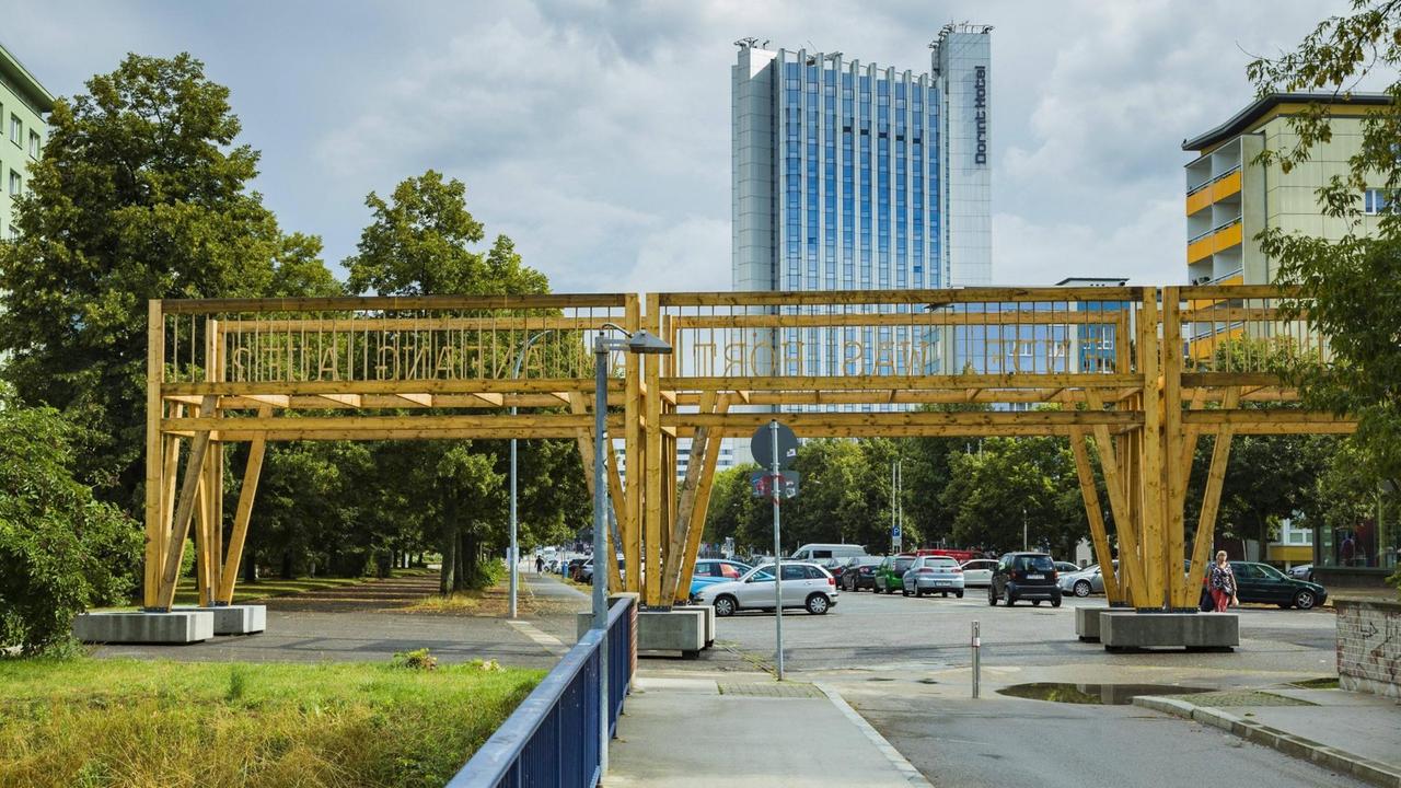 Ein Kunstwerk in Form einer Art unfertigen Brücke über eine Straße in Chemnitz. 