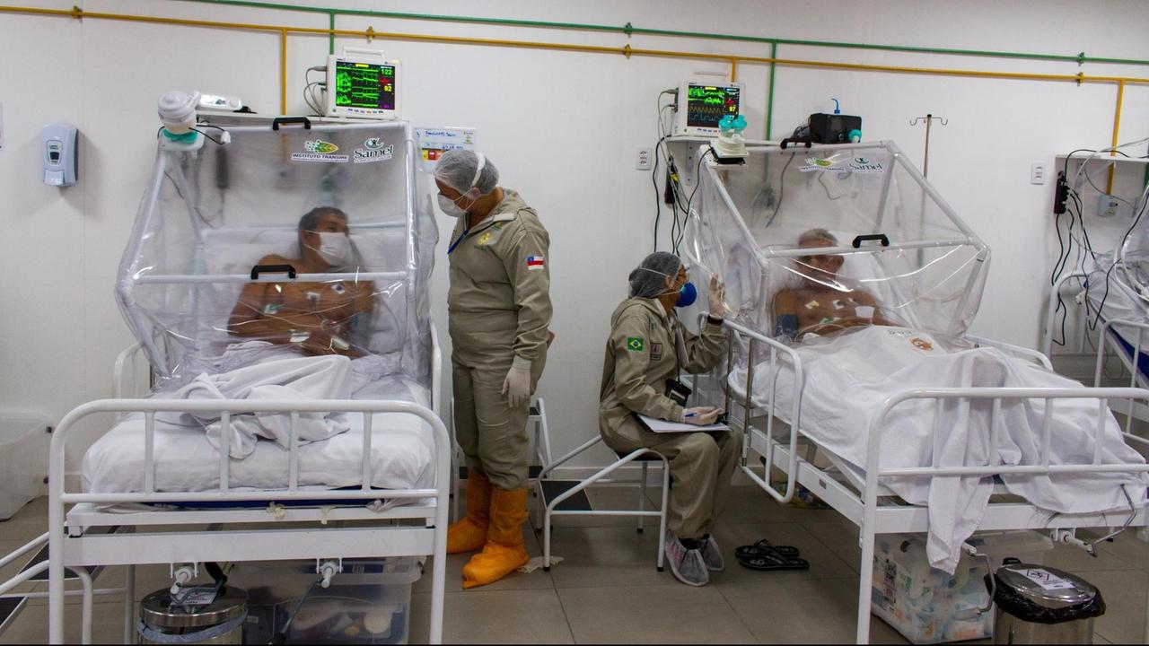 Brasilien, Manaus: Krankenpfleger unterhalten sich mit Patienten auf der Intensivstation im Gilberto Novaes Municipal Field Hospital. Das Feldkrankenhaus wurde in einer Schule eingerichtet. Brasilien, Manaus: Krankenpfleger unterhalten sich mit Patienten auf der Intensivstation im Gilberto Novaes Municipal Field Hospital. Das Feldkrankenhaus wurde in einer Schule eingerichtet.