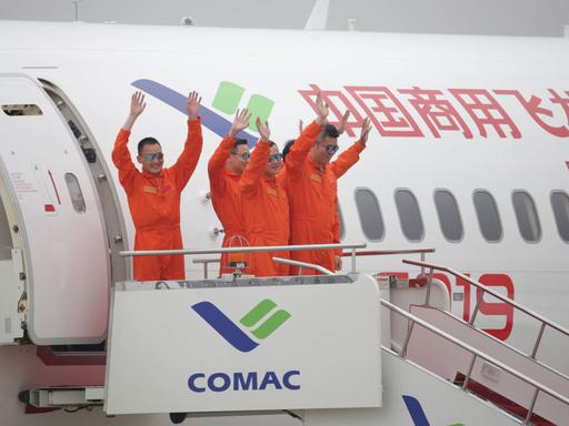 Crew-Mitglieder winken in Schanghai nach dem Jungfernflug der C919, dem ersten vom chinesischen Unternehmen COMAC entwickelten Großflugzeug am 25. Mai 2017. Gestartet war die Maschine in Pudong