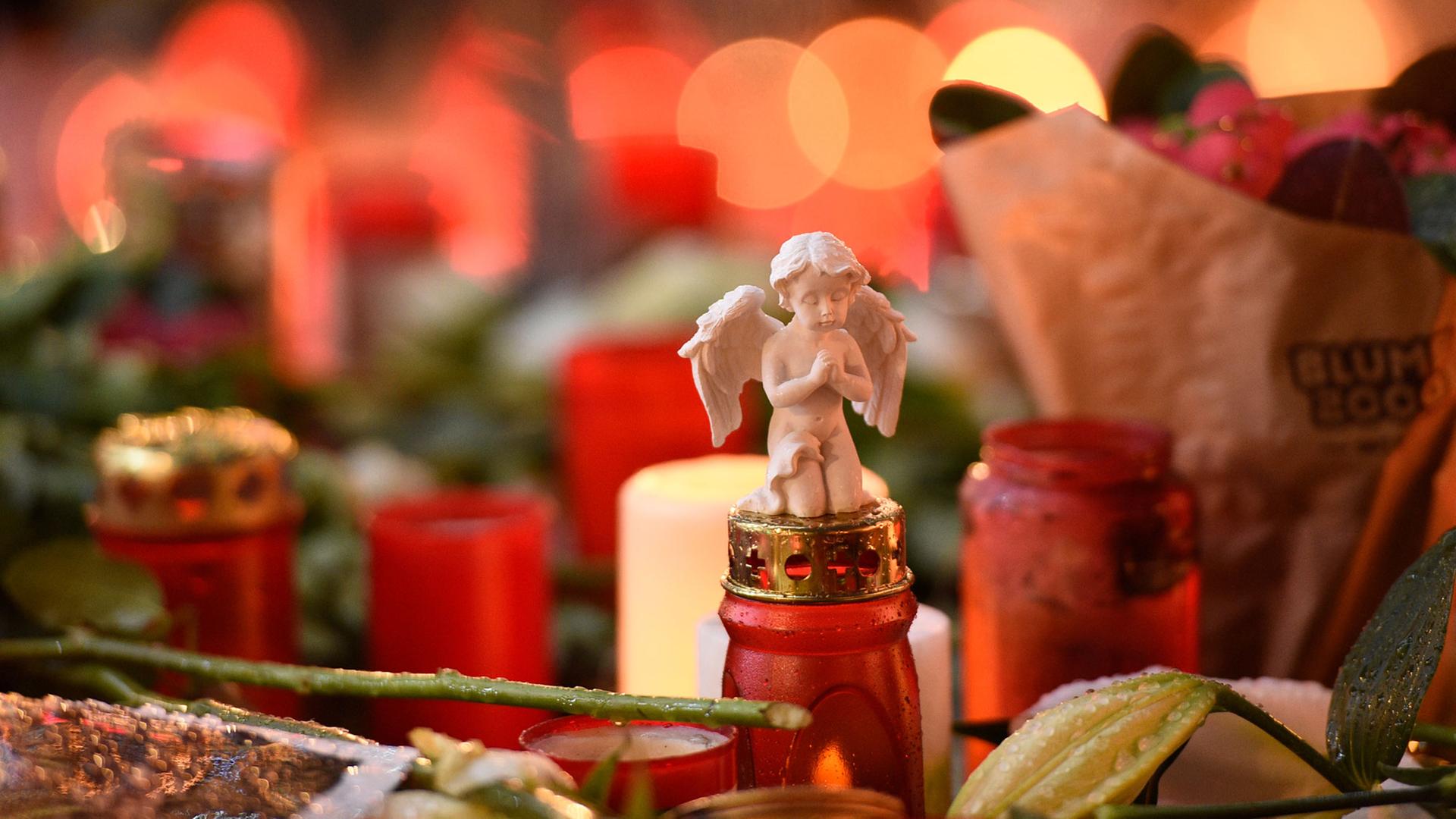 Die kleine Figur eines Engels liegt am 22.12.2016 auf dem Weihnachtsmarkt am Breitscheidplatz in Berlin auf einer Grabkerze. Die kleine Figur eines Engels liegt am 22.12.2016 auf dem Weihnachtsmarkt am Breitscheidplatz in Berlin auf einer Grabkerze.