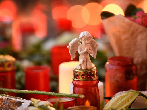 Die kleine Figur eines Engels liegt am 22.12.2016 auf dem Weihnachtsmarkt am Breitscheidplatz in Berlin auf einer Grabkerze.