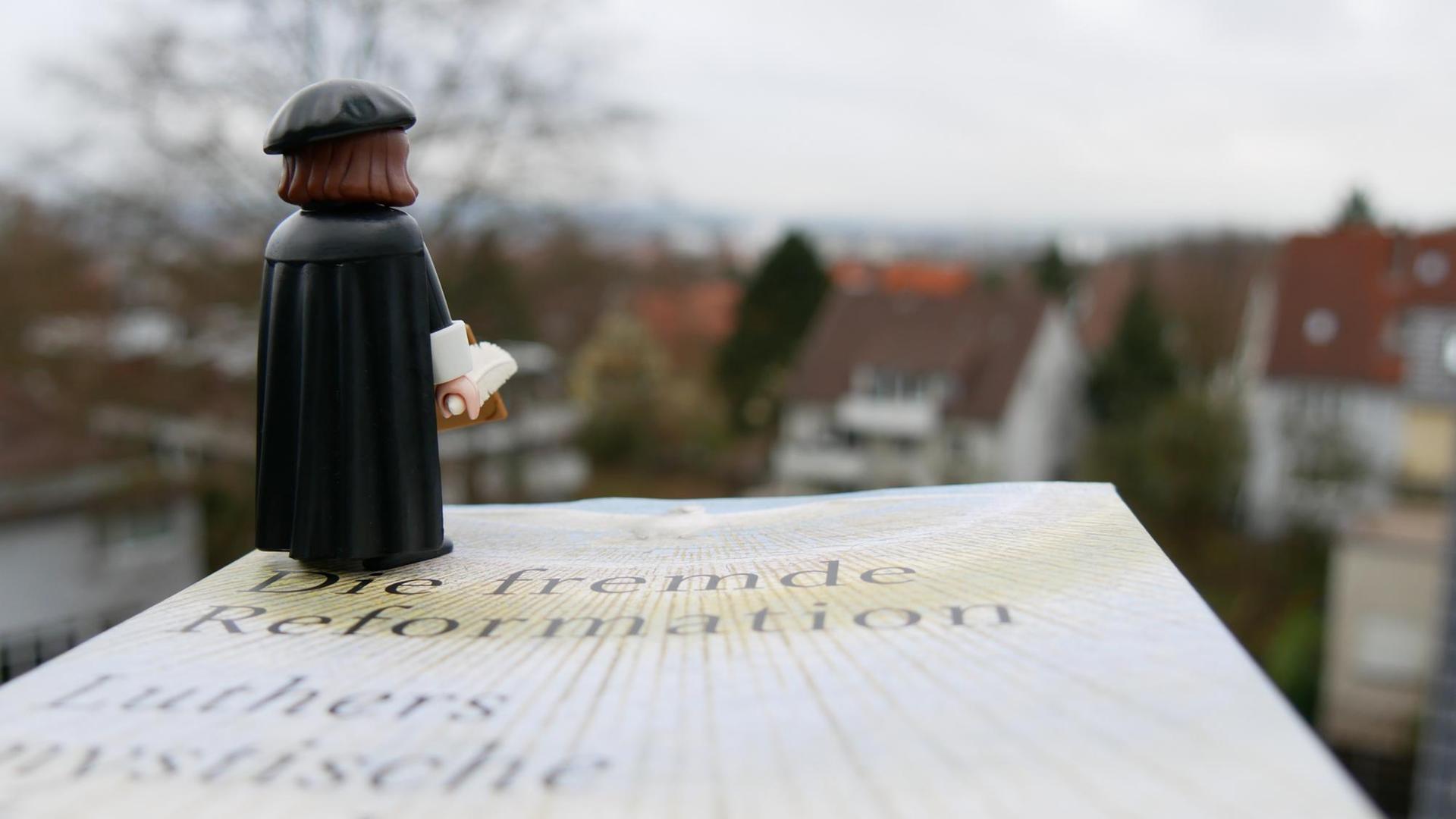Eine Lutherfigur steht auf Volker Leppins Buch "Die fremde Reformation" und blickt in die Ferne. Eine Lutherfigur steht auf Volker Leppins Buch "Die fremde Reformation" und blickt in die Ferne.