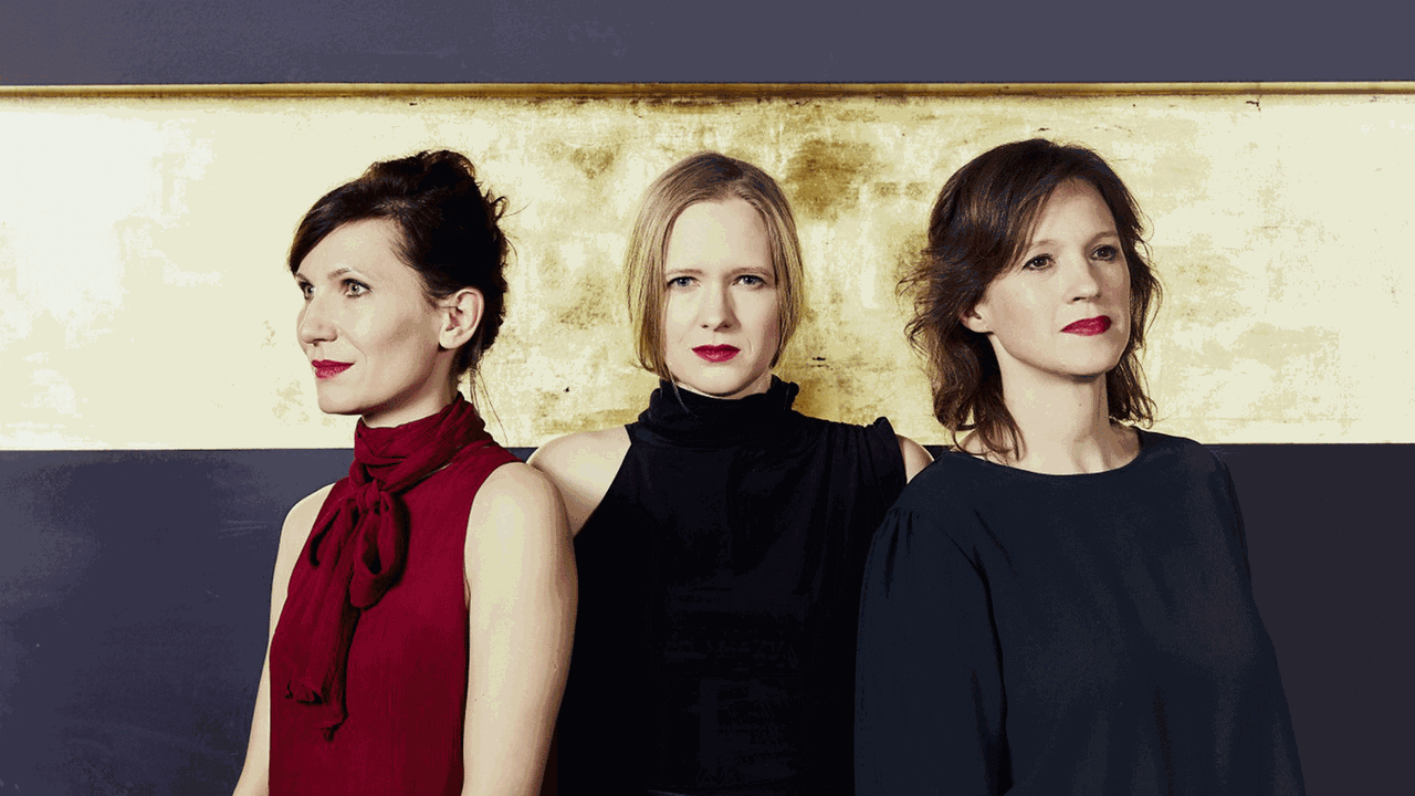 Die Musikerinnen des Boulanger Trios tragen ihre Mission im Namen: Karla Haltenwanger(Klavier), Birgit Erz (Violine) und Ilona Kindt (Violoncello). stehen vor einer Wand, die einen goldenen Streifen zeigt.