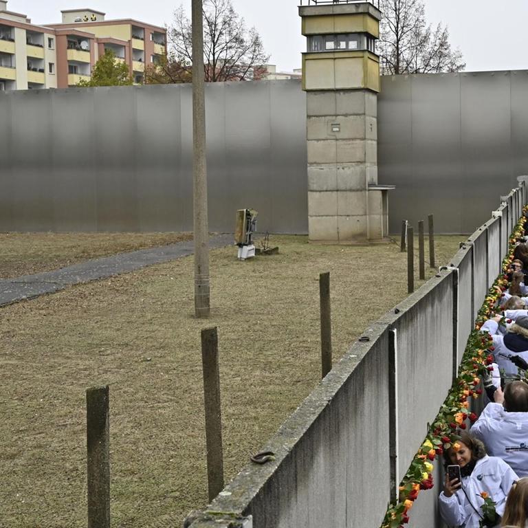 Gäste der Gedenkfeier zum 30. Jahrestag des Mauerfalls erinnern an der Gedenkstätte Bernauer Straße in Berlin mit Blumen an die Mauertoten 