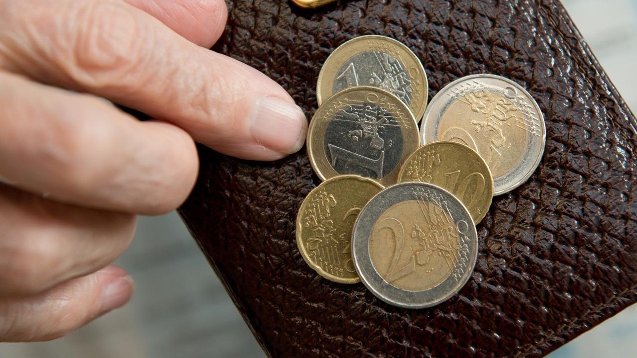Eine Rentnerin zählt die Euros in ihrer Geld-Börse. Eine Rentnerin zählt die Euros in ihrer Geld-Börse.