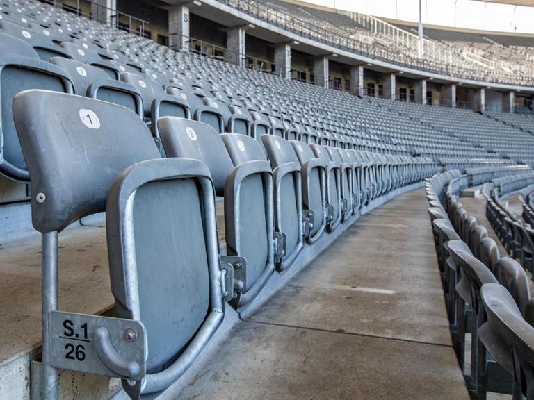 Die Sitze in den Reihen des menschenleeren Olympiastadions sind hochgeklappt.