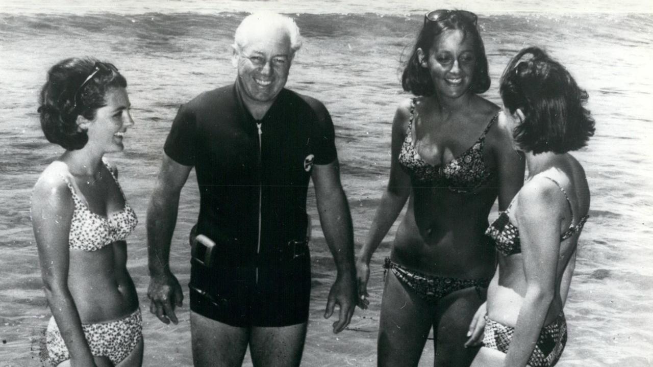 Schwarz-Weiß-Aufnahme des früheren australischen Premierministers Harold Holt mit seinen Schwiegertöchtern am Strand von Portsea. Schwarz-Weiß-Aufnahme des früheren australischen Premierministers Harold Holt mit seinen Schwiegertöchtern am Strand von Portsea.