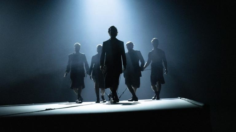 Fünf Schauspieler in dämmerigem Licht. Fünf Schauspieler in dämmerigem Licht.