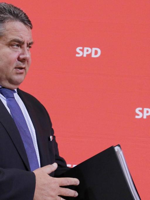 SPD-Parteichef Sigmar Gabriel in Berlin im Willy Brandt Haus geht entlang einer roten Wand mit der Aufschrift SPD
