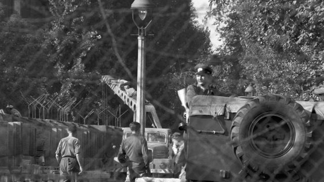 Geschützt durch einen Panzerwagen erhöhen am 12.10.1961 Arbeiter aus Ostberlin die Mauer in der Heidelberger Straße an der Grenze zum westberliner Bezirk Neukölln.