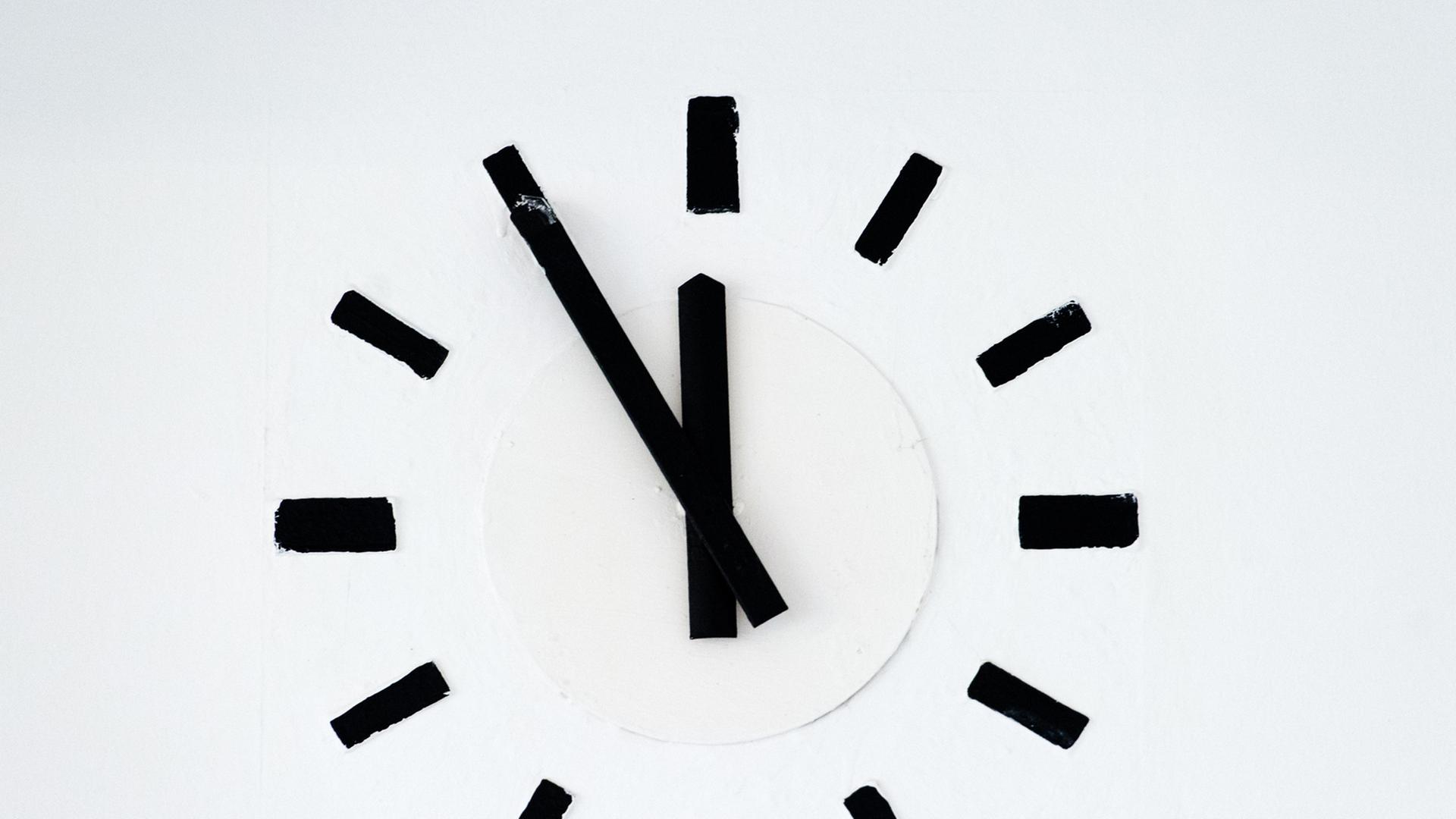 Eine Uhr zeigt fünf vor zwölf. Eine Uhr zeigt fünf vor zwölf.