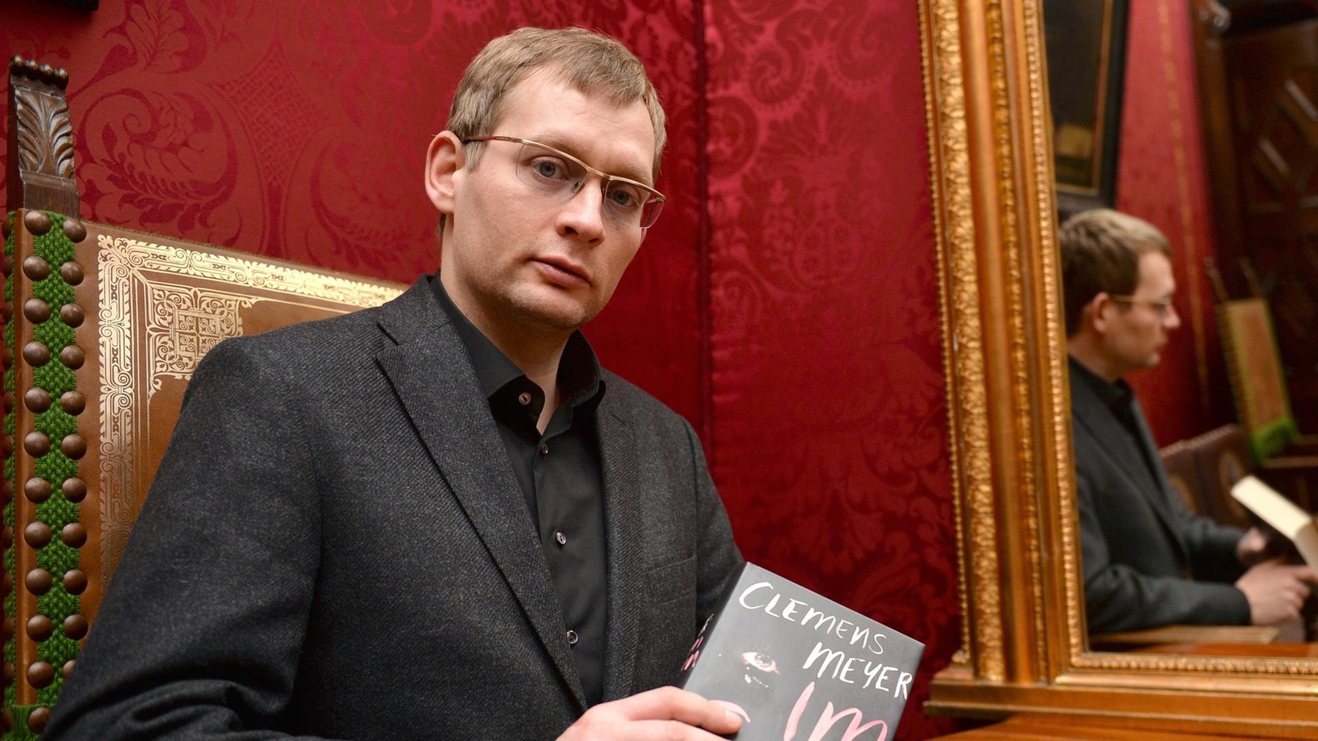 Der Schriftsteller Clemens Meyer vor der Verleihung des Bremer Literaturpreises 2014 mit seinem Buch. Der Schriftsteller Clemens Meyer vor der Verleihung des Bremer Literaturpreises 2014 mit seinem Buch.