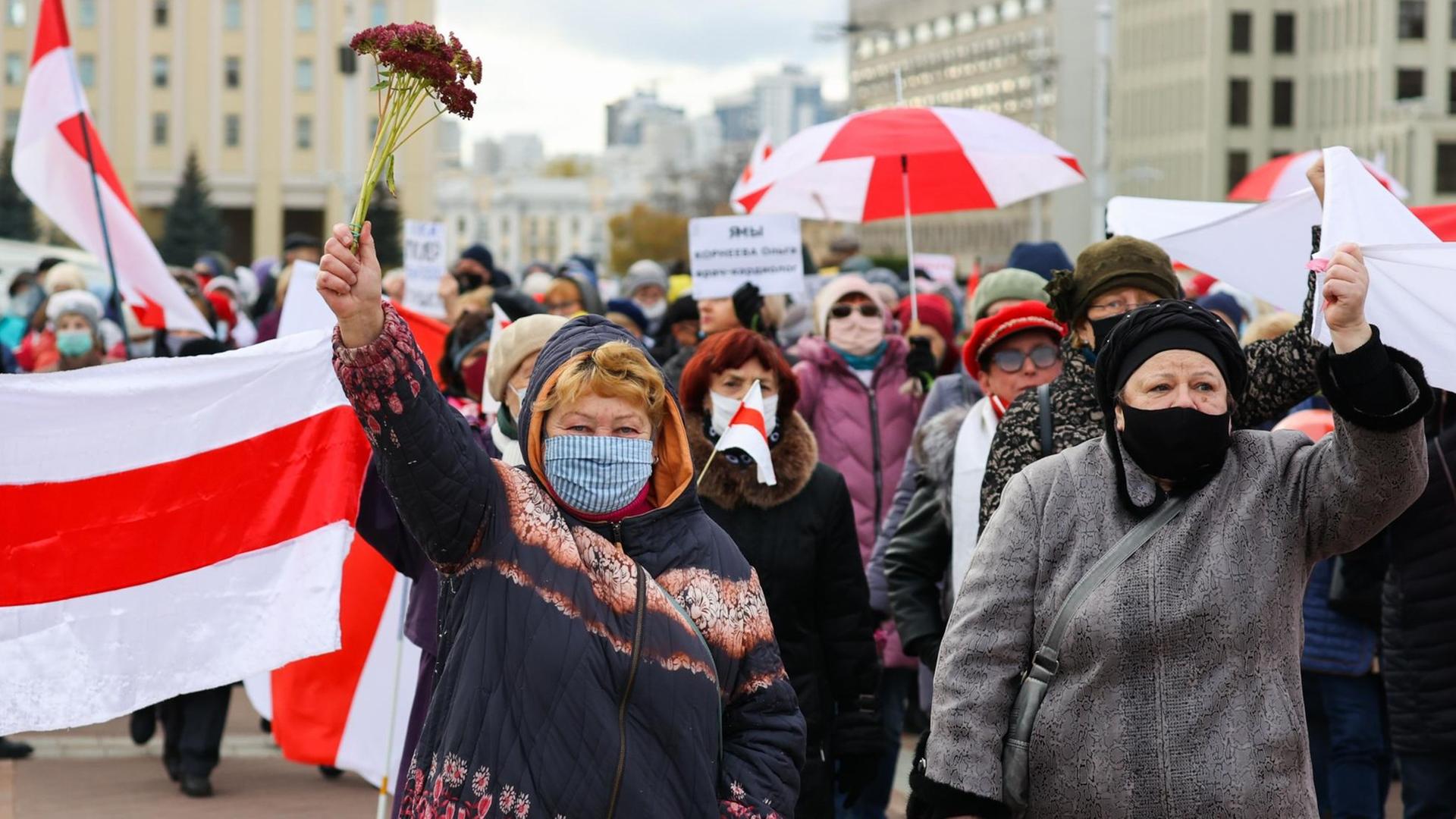 Anti-Lukaschenko Protest in Belarus: Kritiker des Machthabers laufen durch Minsk, einer von ihnen hält eine weiß-rote Flagge Anti-Lukaschenko Protest in Belarus: Kritiker des Machthabers laufen durch Minsk, einer von ihnen hält eine weiß-rote Flagge