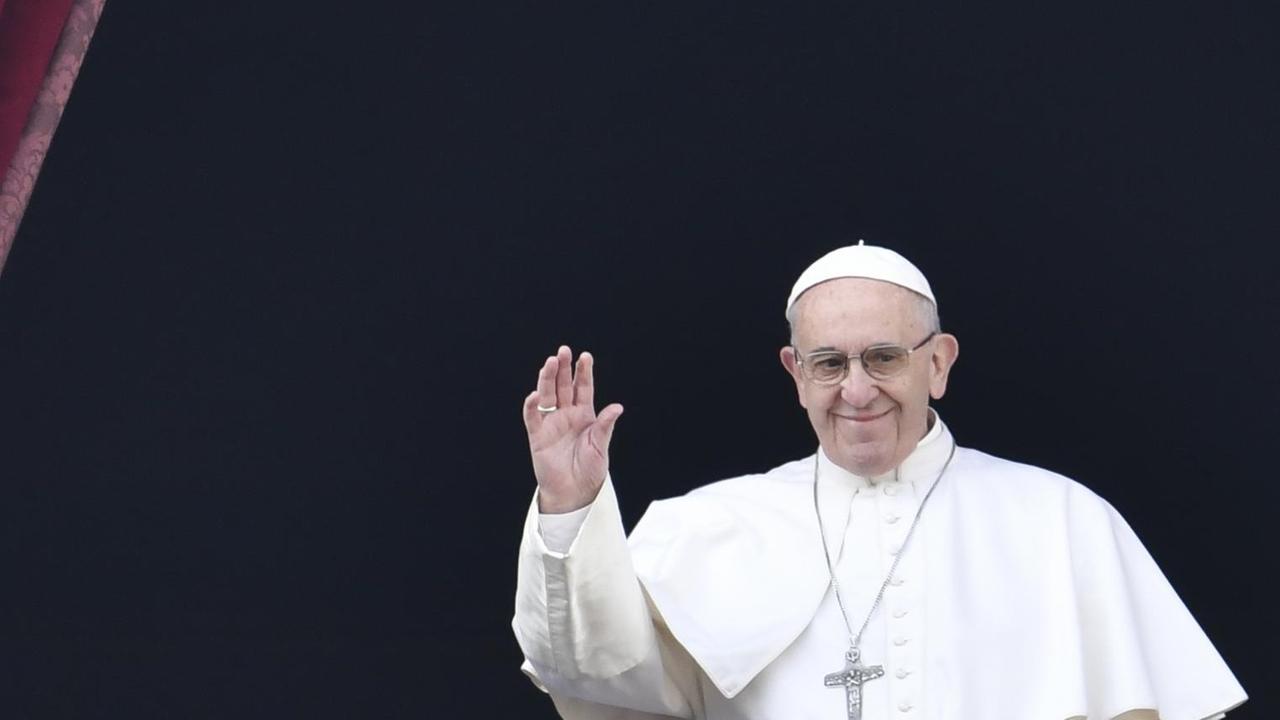 Der Papst steht auf dem Balkon über dem Petersplatz und spendet seinen Segen. Der Papst steht auf dem Balkon über dem Petersplatz und spendet seinen Segen.
