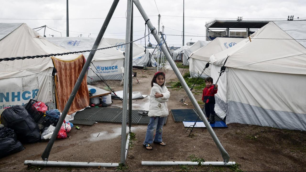 Kinder stehen zwischen den Zelten eines Flüchtlingslagers.