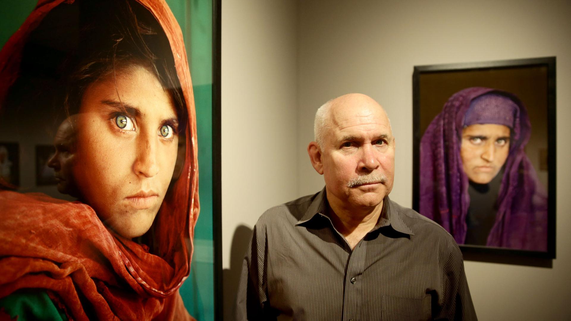Der US-amerikanische Fotograf Steve McCurry 2013 in der Ausstellung "Steve McCurry. Überwältigt vom Leben" im Museum für Kunst und Gewerbe in Hamburg zwischen seinen Bildern. Der US-amerikanische Fotograf Steve McCurry 2013 in der Ausstellung "Steve McCurry. Überwältigt vom Leben" im Museum für Kunst und Gewerbe in Hamburg zwischen seinen Bildern.