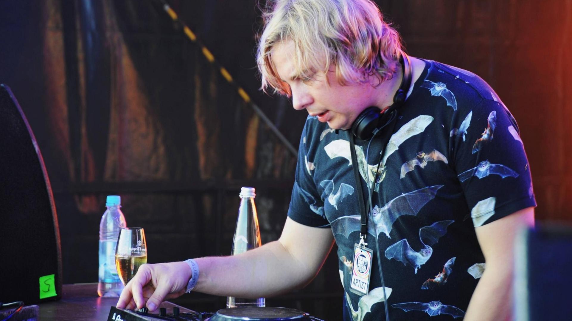 Dominik Eulberg, ein deutscher DJ und Produzent im Bereich Minimal Techno, steht konzentriert bei einem seiner Auftritte hinter dem DJ Pult. Dominik Eulberg, ein deutscher DJ und Produzent im Bereich Minimal Techno, steht konzentriert bei einem seiner Auftritte hinter dem DJ Pult.