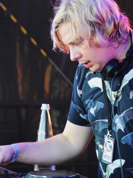 Dominik Eulberg, ein deutscher DJ und Produzent im Bereich Minimal Techno, steht konzentriert bei einem seiner Auftritte hinter dem DJ Pult.