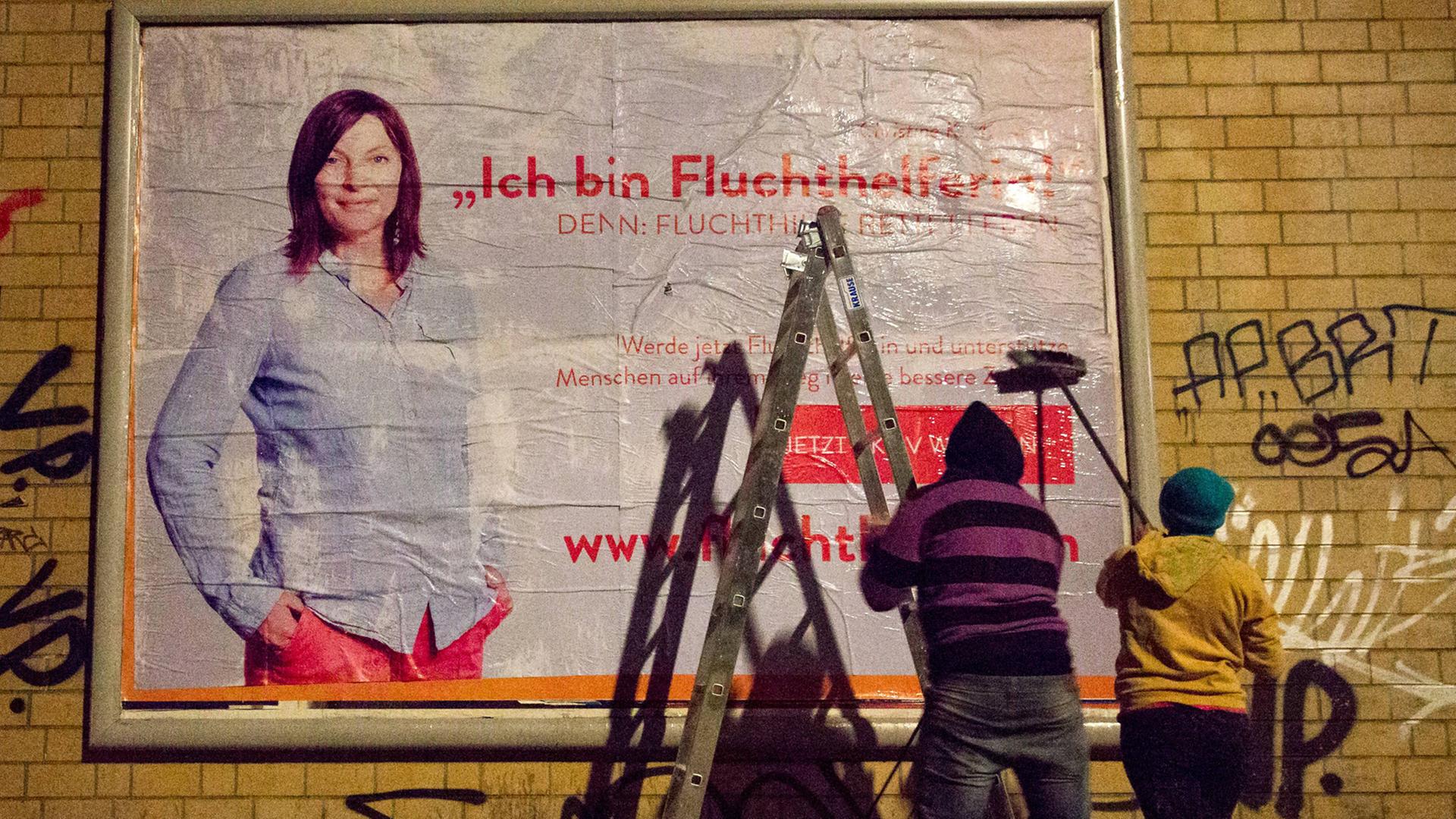 Peng-Aktivisten plakatieren in der Nähe der Berliner Ausländerbehöre ein Plakat mit der Aufschrift: "Ich bin Fluchthelferin!" Am selben Tag startete eine Kampagne für zivilen Ungehorsam, in dem die Aktivisten Urlauber zur Fluchthilfe auffordern. Peng-Aktivisten plakatieren in der Nähe der Berliner Ausländerbehöre ein Plakat mit der Aufschrift: "Ich bin Fluchthelferin!" Am selben Tag startete eine Kampagne für zivilen Ungehorsam, in dem die Aktivisten Urlauber zur Fluchthilfe auffordern.