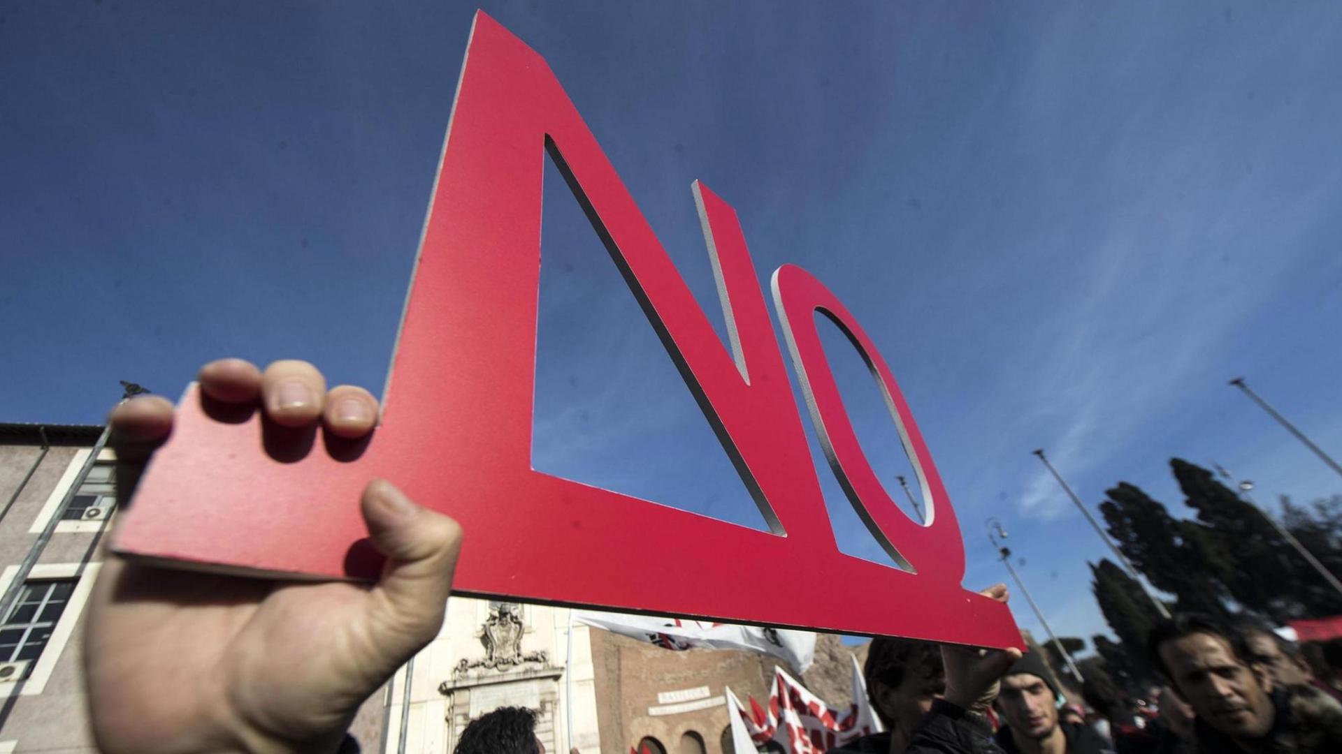 Ein Demonstrant hält einen Schriftzug "NO" hoch. Ein Demonstrant hält einen Schriftzug "NO" hoch.