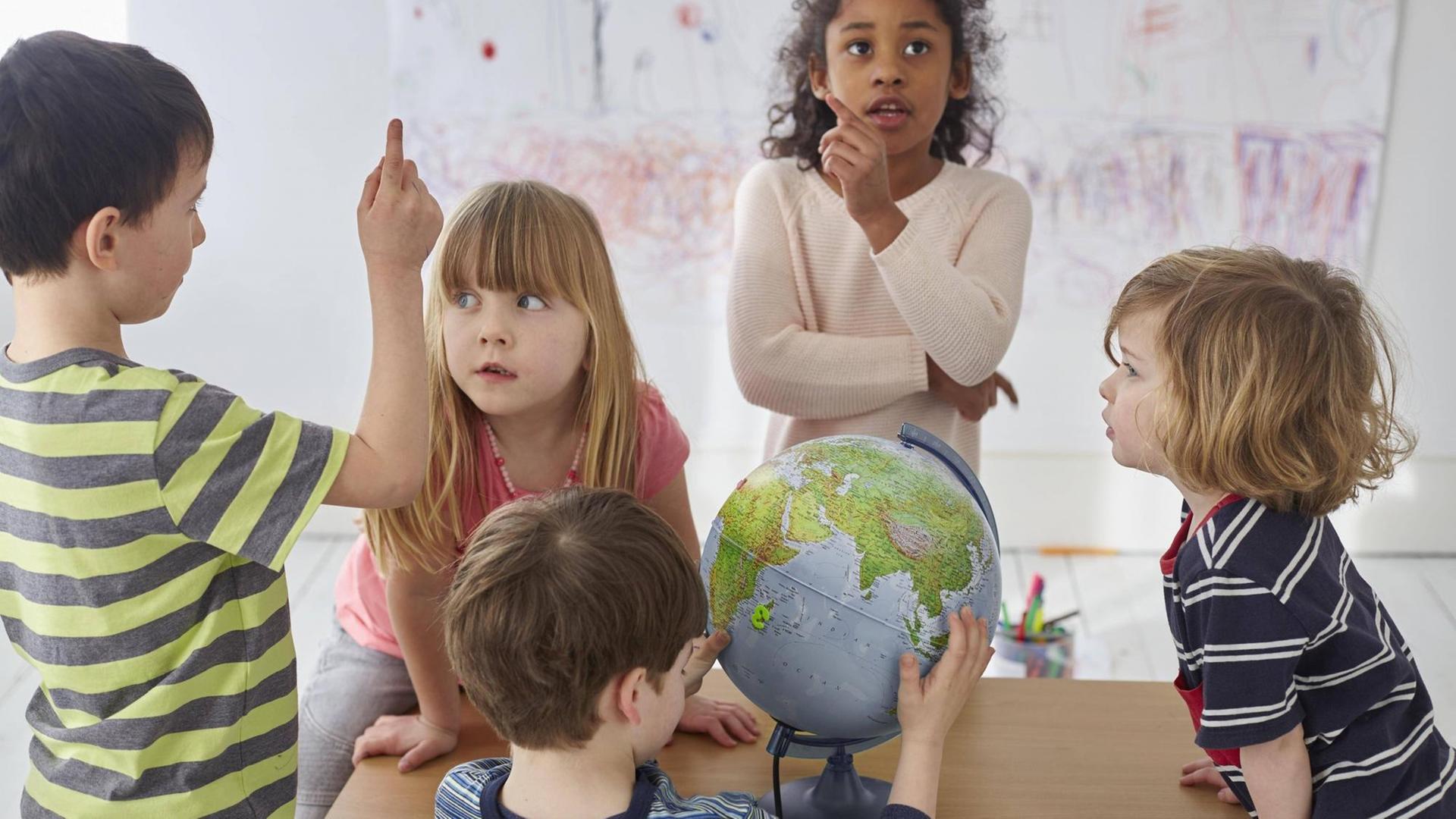 Diskutierende Kinder um einen Tisch, mit einem Globus. Diskutierende Kinder um einen Tisch, mit einem Globus.