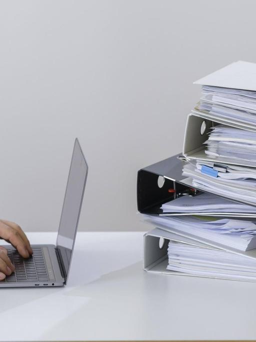 Symbolfoto zum Thema Digitalisierung in der Verwaltung . Ein Computer liegt neben einem Haufen Aktenordner. Berlin, 29.05.2019. Berlin Deutschland *** Symbol photo on the subject of digitisation in administration A computer lies next to a pile of files Berlin, 29 05 2019 Berlin Germany PUBLICATIONxINxGERxSUIxAUTxONLY Copyright: xThomasxTrutschel/photothek.netx