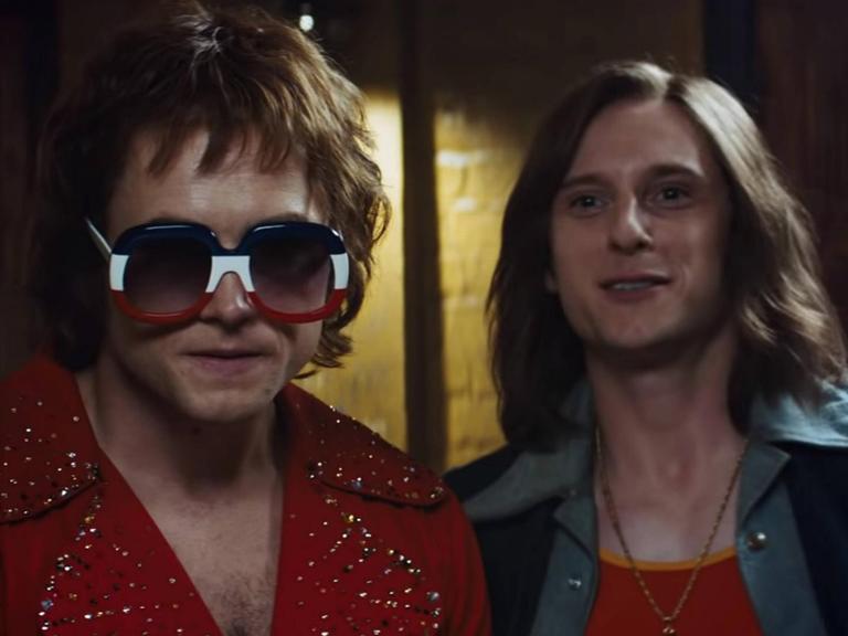 Taron Egerton als Elton John und Jamie Bell als Bernie Taupin in schrillen Bühnenkostümen