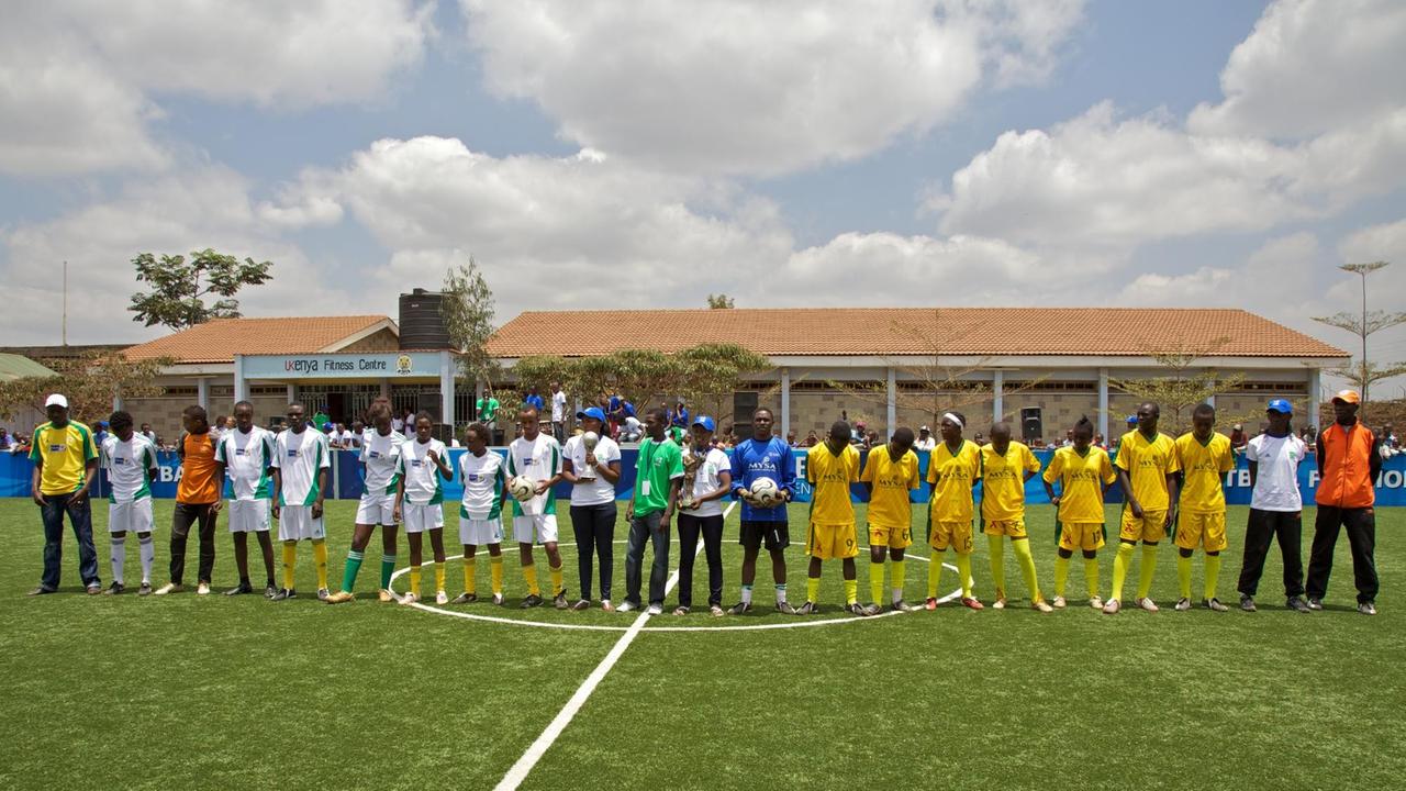 Mannschaften stehen in Reihe auf dem Spielfeld während der Eröffnungszeremonie des Mathare FIFA Football For Hope Zentrums am 4. September 2010 in Nairobi, Kenia. Mannschaften stehen in Reihe auf dem Spielfeld während der Eröffnungszeremonie des Mathare FIFA Football For Hope Zentrums am 4. September 2010 in Nairobi, Kenia.