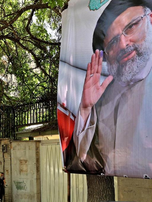 Ein Fußgängerin geht in der iranischen Hauptstadt Teheran an einem Wahlplakat des Präsidentschaftskandidaten Ebrahim Raisi vorbei.