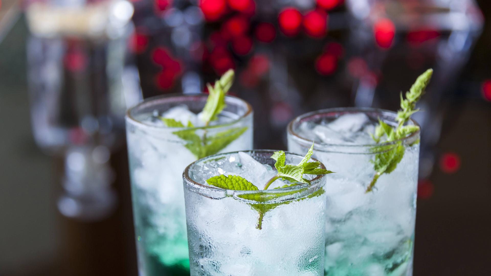 Drei Cocktails mit Minzlikör und Eiswürfeln in Gläsern Drei Cocktails mit Minzlikör und Eiswürfeln in Gläsern