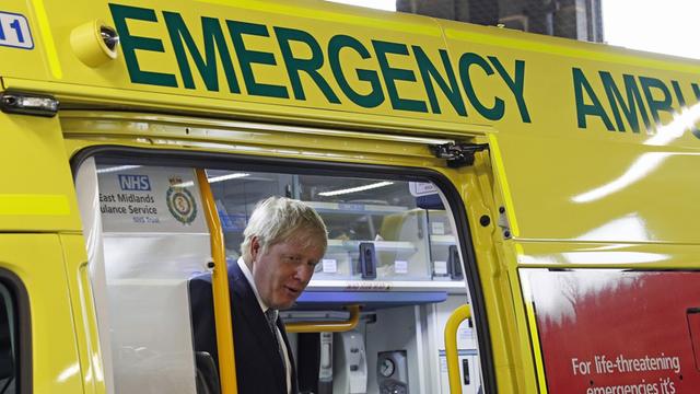 Boris Johnson steht in einem Krankenwagen, den er besichtigt.