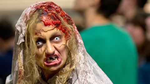 Eine Frau hat sich zu Halloween als Zombie verkleidet.