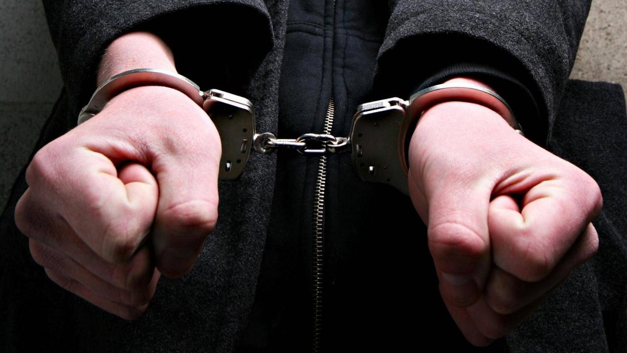 Junger Mann mit Handschellen. Junger Mann mit Handschellen.