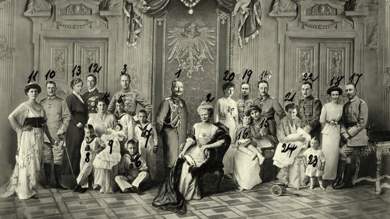 1. Kaiser Wilhelm II., 2. Kaiserin Auguste Viktoria, 3. Kronprinz Wilhelm, 4. Kronprinzessin Cecilie, 5. Prinz Wilhelm, 6. Prinz Louis Ferdinand, 7. Prinz Hubertus, 8. Prinz Friedrich, 9. Prinzessin Alexandrine, 10. Prinz Eitel Friedrich, 11, Prinzessin Sophie Charlotte von Oldenburg, 12. Prinz Adalberg, 13. Prinzessin Adelheid von Sachsen-Meiningen, 14. Prinz August Wilhelm, Prinzessin Alexandra Viktoria zu Schleswig-Holstein-Sonderburg-Glücksburg, 16. Prinz Alexander Ferdinand, 17. Prinz Oskar, 18. Ina Marie Gräfin Bassewitz, 19. Prinz Joachim, 20. Prinzessin Marie Auguste von Anhalt, 21. Herzogin Viktoria Luise von Braunschweig, 22. Herzog Ernst August von Braunschweig, 23. Prinz Ernst August, Prinz Georg Wilhelm 1. Kaiser Wilhelm II., 2. Kaiserin Auguste Viktoria, 3. Kronprinz Wilhelm, 4. Kronprinzessin Cecilie, 5. Prinz Wilhelm, 6. Prinz Louis Ferdinand, 7. Prinz Hubertus, 8. Prinz Friedrich, 9. Prinzessin Alexandrine, 10. Prinz Eitel Friedrich, 11, Prinzessin Sophie Charlotte von Oldenburg, 12. Prinz Adalberg, 13. Prinzessin Adelheid von Sachsen-Meiningen, 14. Prinz August Wilhelm, Prinzessin Alexandra Viktoria zu Schleswig-Holstein-Sonderburg-Glücksburg, 16. Prinz Alexander Ferdinand, 17. Prinz Oskar, 18. Ina Marie Gräfin Bassewitz, 19. Prinz Joachim, 20. Prinzessin Marie Auguste von Anhalt, 21. Herzogin Viktoria Luise von Braunschweig, 22. Herzog Ernst August von Braunschweig, 23. Prinz Ernst August, Prinz Georg Wilhelm