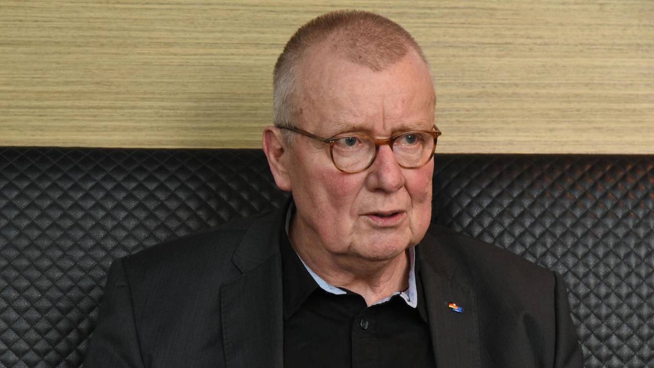 Ruprecht Polenz sitzt im Anzug vor einer Wand gestikuliert Ruprecht Polenz sitzt im Anzug vor einer Wand gestikuliert