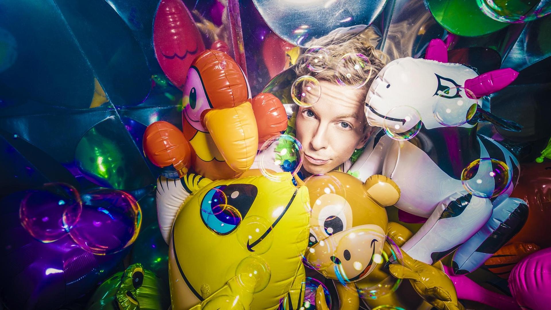Comedian Marcel Mann inmitten von bunten Luftballontieren. Comedian Marcel Mann inmitten von bunten Luftballontieren.
