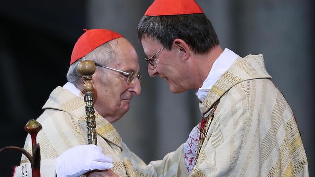 Der Kölner Erzbischof Rainer Maria Woelki (r) nimmt am 20.09.2014 in Köln von seinem Vorgänger Kardinal Joachim Meisner (l) den Petrusstab entgegen