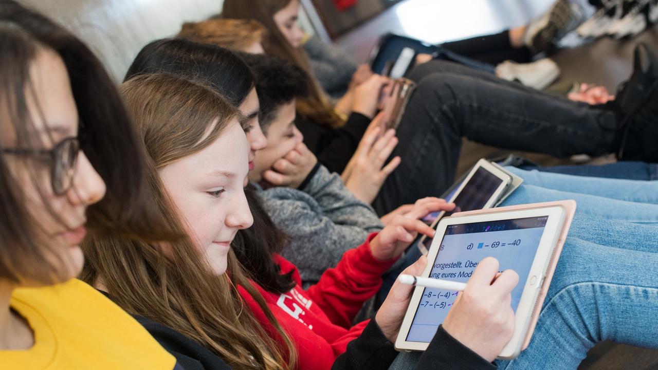 Schüler einer 7. Klasse sitzen auf dem Boden und lernen mit iPads im Matheunterricht an der Oberschule Gehrden in der Region Hannover. Schüler einer 7. Klasse sitzen auf dem Boden und lernen mit iPads im Matheunterricht an der Oberschule Gehrden in der Region Hannover.