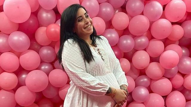 YouTuberin Jolina Mennen im weißen Kleid vor rosa Luftballons.