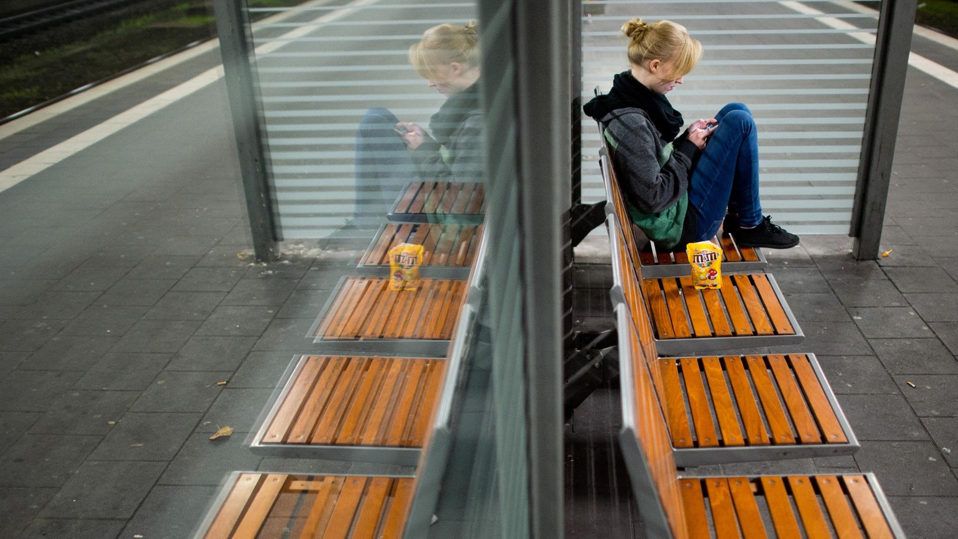 Eine junge Frau wartet am späten Abend vom 06.11.2014 am Bahnhof in Hildesheim (Niedersachsen) auf einen Zug. Eine junge Frau wartet am späten Abend vom 06.11.2014 am Bahnhof in Hildesheim (Niedersachsen) auf einen Zug.