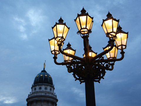 Alte Laternen leuchten in der blauen Stunde am Gendarmenmarkt im Bezirk Mitte in Berlin. Alte Laternen leuchten in der blauen Stunde am Gendarmenmarkt im Bezirk Mitte in Berlin.