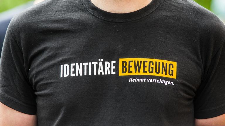 Mitglied der "Identitären Bewegung" trägt ein T-Shirt mit dem Namen der Gruppe bei einer Demonstration in München
