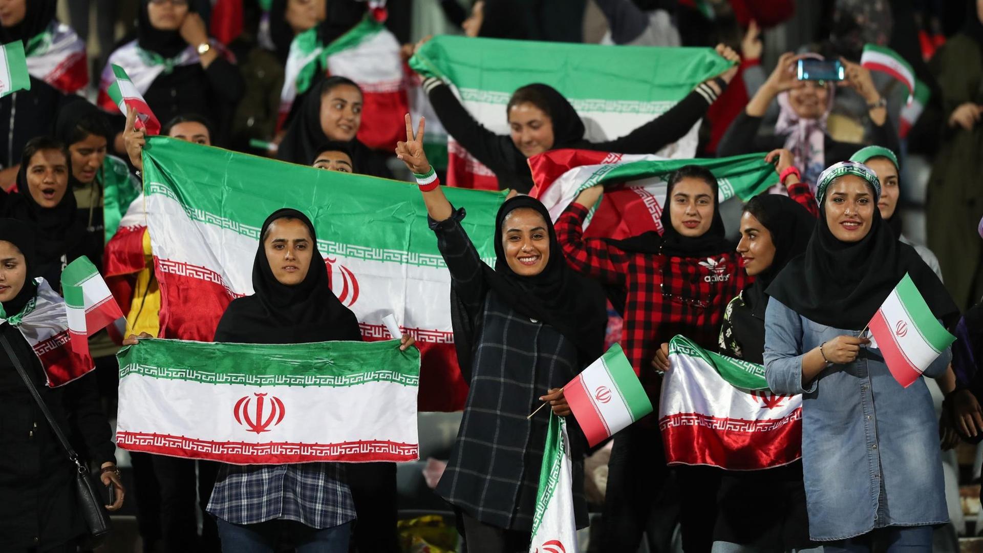 Iranische Frauen schwenken während des Spiels gegen Bolivien Nationalflaggen auf der Tribüne. Iranische Frauen schwenken während des Spiels gegen Bolivien Nationalflaggen auf der Tribüne.